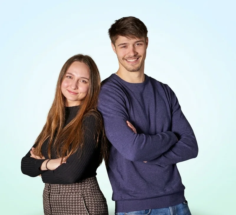 Alex und Valeria, die Gründer von Orthamedic, stehen Rücken an Rücken mit verschränkten Armen und lächeln
